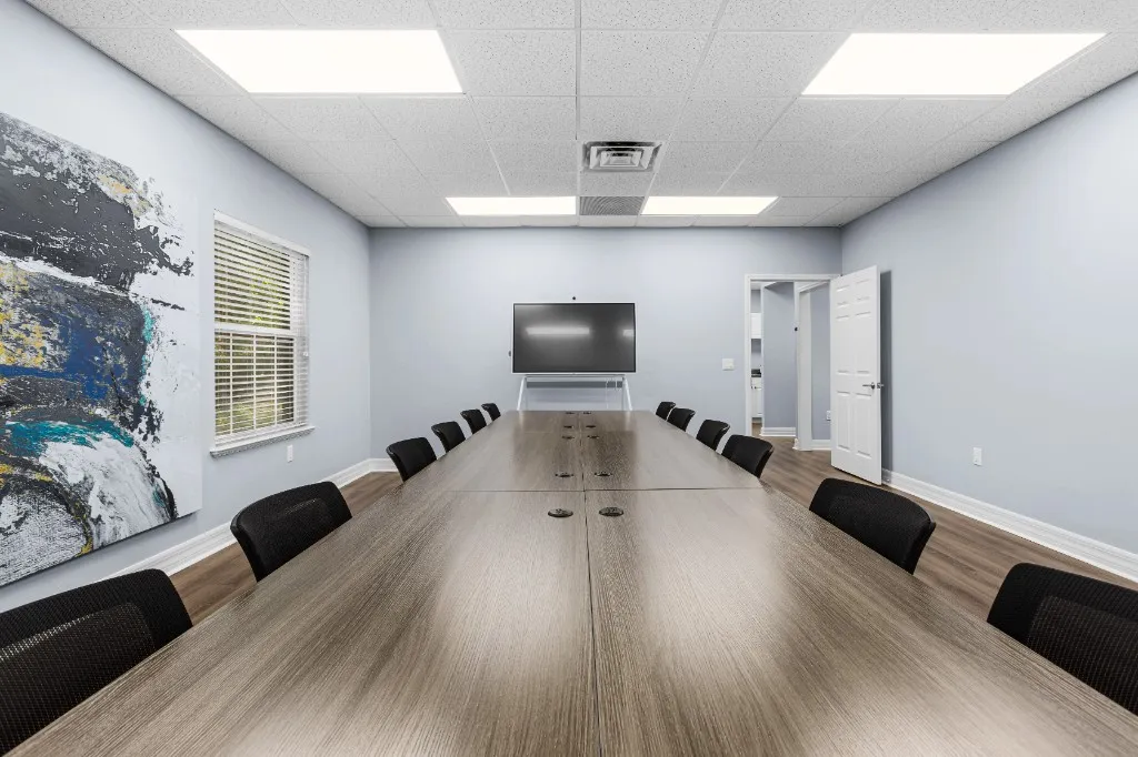 Long conference table with seating facing a presentation display at the far end of the room, ProSpace Gainesville